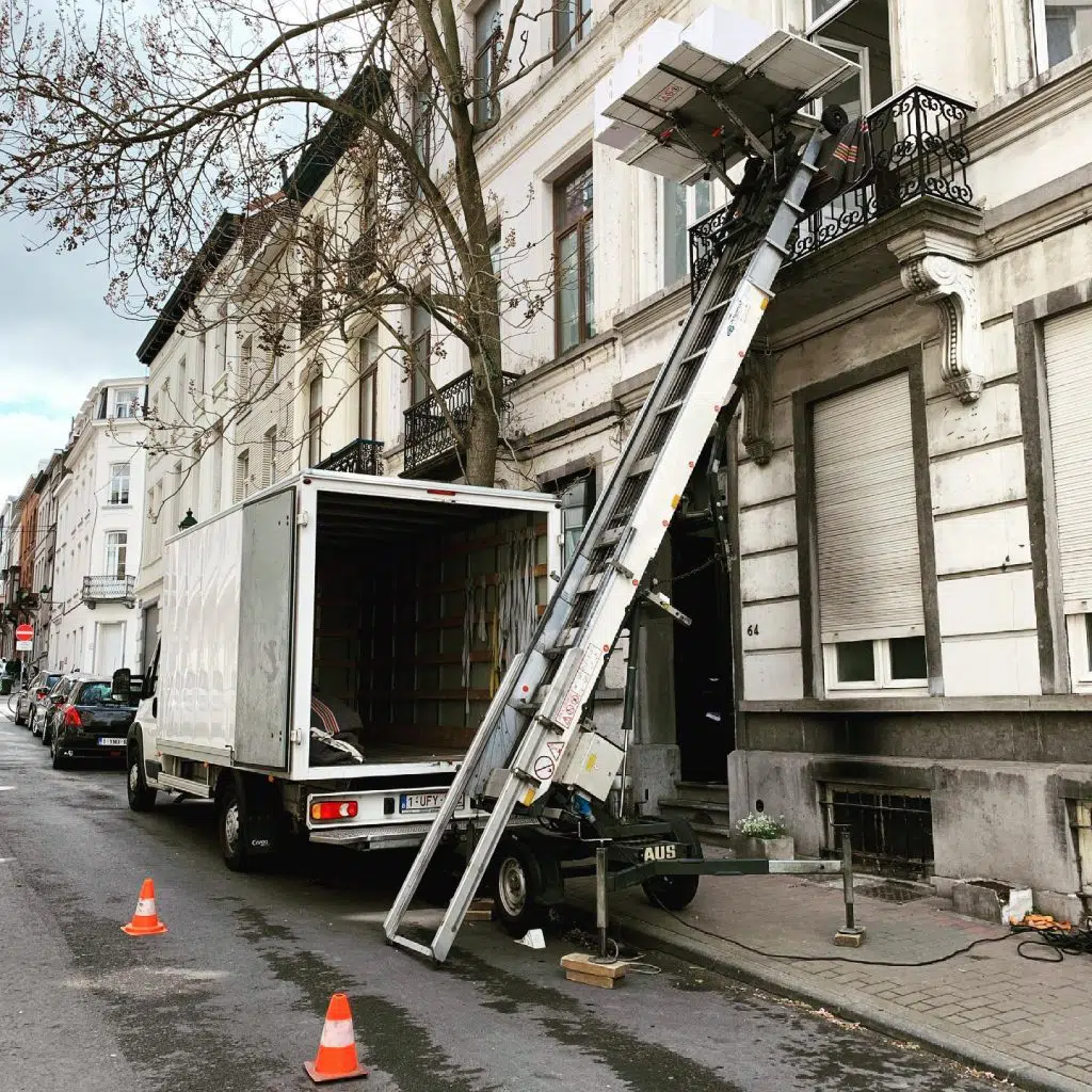 Grúa montamuebles de Mudanza BCN elevando muebles junto a un camión de mudanza en Barcelona